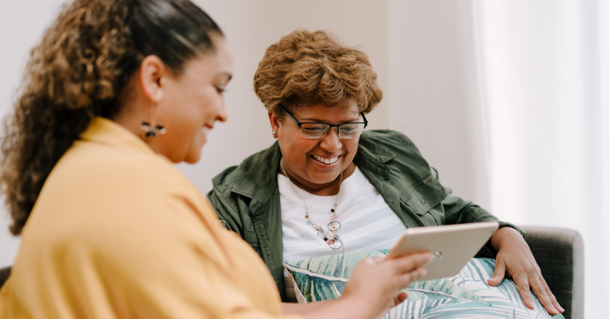 Photo of two women -- one holding a tablet for an older lady